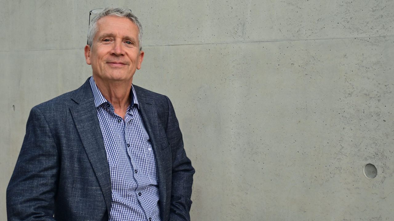 Christoph Hein vor einer Wand aus Sichtbeton